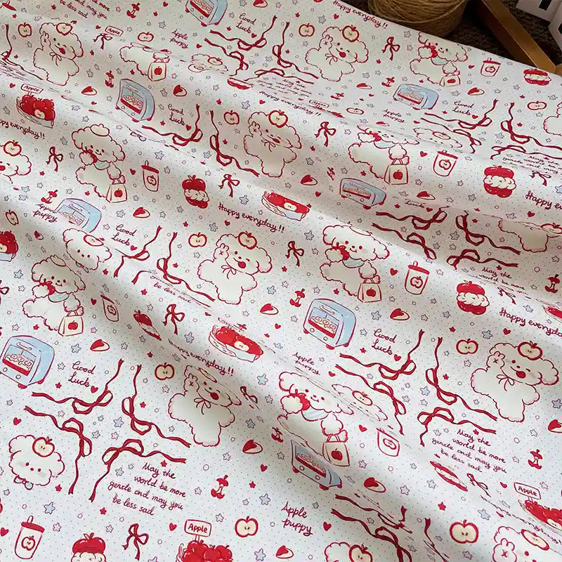 Puppy Apple Print Canvas Fabric By The Yard in cream-colored cotton canvas featuring a red line-art pattern of puppies, apples, ribbons, and small text.