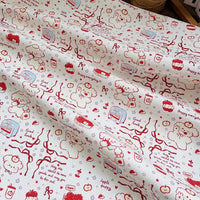 Puppy Apple Print Canvas Fabric By The Yard in cream-colored cotton canvas featuring a red line-art pattern of puppies, apples, ribbons, and small text.