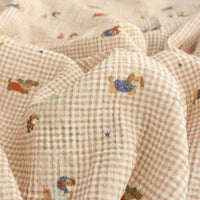 Longan Craft Puppy Print Gingham Double Gauze Fabric by the yard is a brown plaid pure cotton, breathable gauze material with playful cartoon puppies and blue stars—ideal for baby clothes and sleepwear.