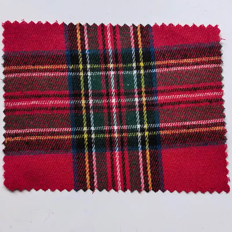 A rectangular sample of Longan Craft’s “Red Checked Cotton Flannel Fabric By The Yard” is shown here, featuring a Scottish-style vintage plaid pattern in red, green, yellow, black, and white. The single-sided brushed flannel material has zigzag pinked edges, displayed against a plain light gray background.