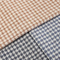 Three folded pieces of Longan Craft’s Retro Houndstooth Jacquard Tweed Fabric By The Yard—a wool polyester blend—are shown in light brown, blue, and black color combinations. These vintage-inspired tweed fabrics overlap neatly, emphasizing their classic houndstooth pattern and rich texture.