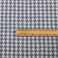 A wooden ruler lies on Longan Craft’s Retro Houndstooth Jacquard Tweed Fabric by the yard, a wool polyester blend tweed material for coats, showcasing the scale of the vintage-inspired blue and white pattern.