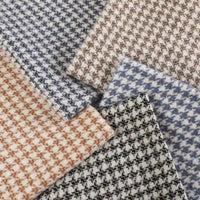 Five pieces of the Retro Houndstooth Jacquard Tweed Fabric By The Yard from Longan Craft, featuring a durable wool-polyester blend, are displayed in an overlapping, fan-shaped arrangement. Showcasing color combinations such as blue, brown, beige, and black, each vintage-inspired tweed fabric highlights the classic houndstooth pattern with a contemporary flair—perfect for crafting timeless coats.