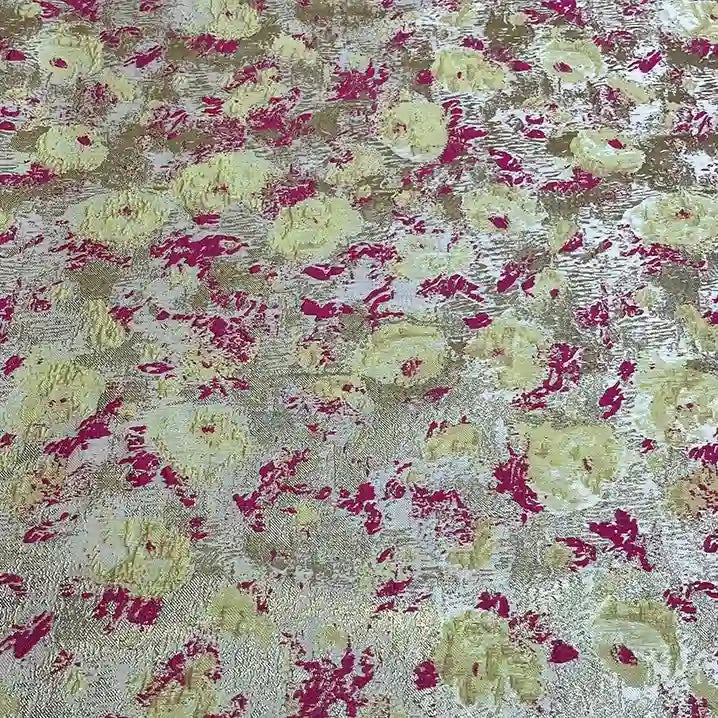 A close-up of Longan Craft's Rose Jacquard Brocade Fabric By The Yard reveals a retro abstract floral design with painterly yellow, gold, and pink tones on a light background. Shimmering golden metallic details add elegant texture, perfect for formal dresses.