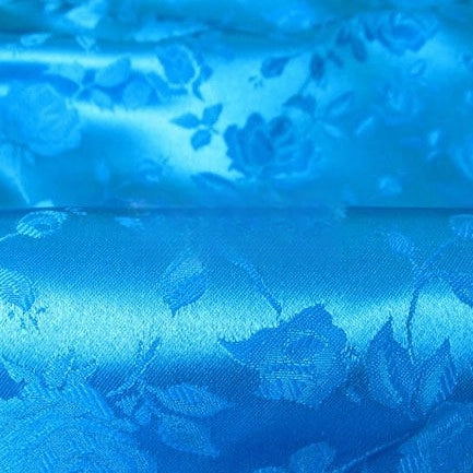 Close-up of Rose Jacquard Satin Fabric By The Yard by Longan Craft, a colorful polyester satin material with a shiny finish and subtle rose and leaf pattern—ideal for costumes.