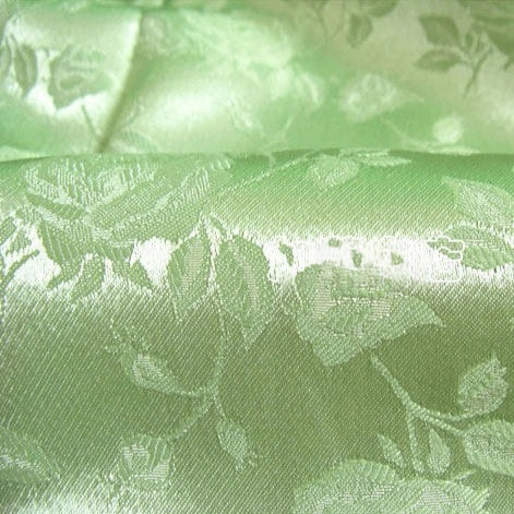 Close-up of Longan Craft’s Rose Jacquard Satin Fabric By The Yard, a colorful polyester satin with a subtle woven floral leaf pattern and luxurious sheen—ideal for costumes and elegant creations.