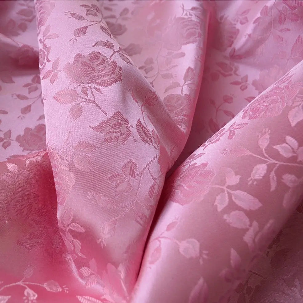 Close-up of Longan Craft’s Rose Jacquard Satin Fabric by the Yard—colorful polyester with a woven rose and leaf pattern. The softly draped satin highlights its smooth texture and is ideal for costumes and creative projects.