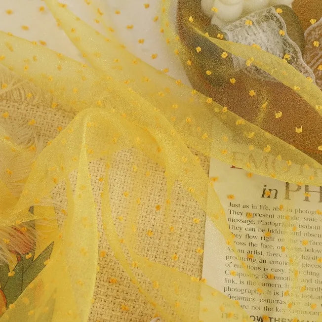 Sheer Swiss Dot Organza Fabric By The Yard in yellow, decorated with small, raised 3D yellow dots.