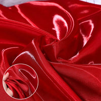 Shiny Liquid Satin Fabric by the Yard from Longan Craft features a smooth, glossy red texture ideal for bridesmaid dresses and formalwear. An inset shows a hand pinching this soft, luxurious polyester satin textile.