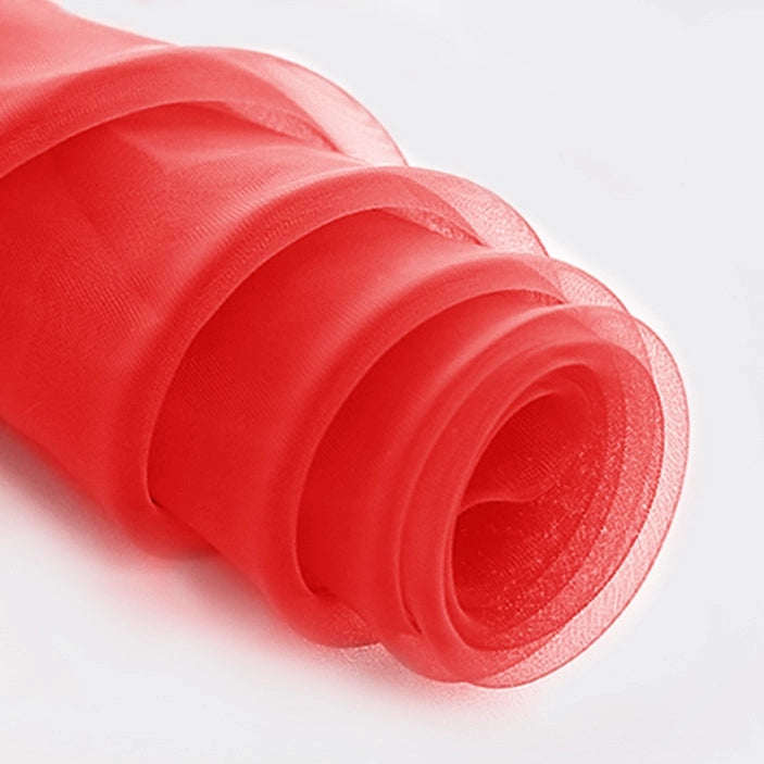 A close-up of Longan Craft's Silky Polyester Organza Fabric By The Yard in sheer red, featuring soft, translucent layers—this premium solid color fabric is perfect for bridal gowns or elegant evening dresses.