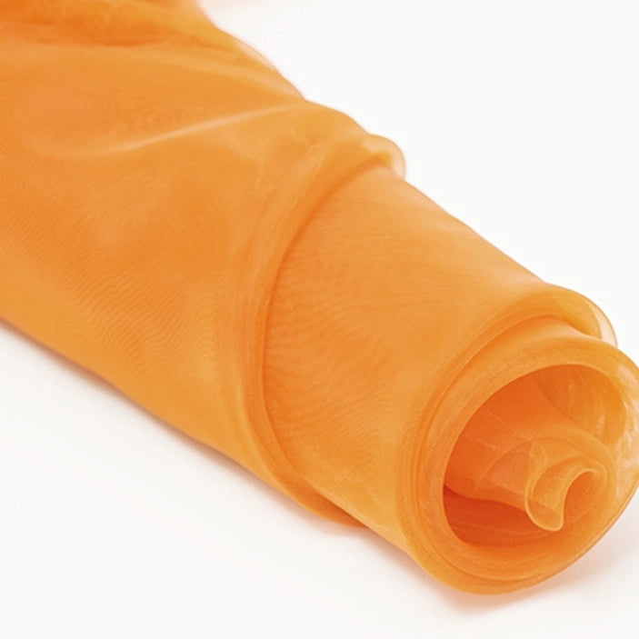 A close-up of a vibrant orange Silky Polyester Organza Fabric by the yard from Longan Craft, partially unrolled on a white background—perfect for bridal gowns or evening dresses with its soft, sheer, premium quality.