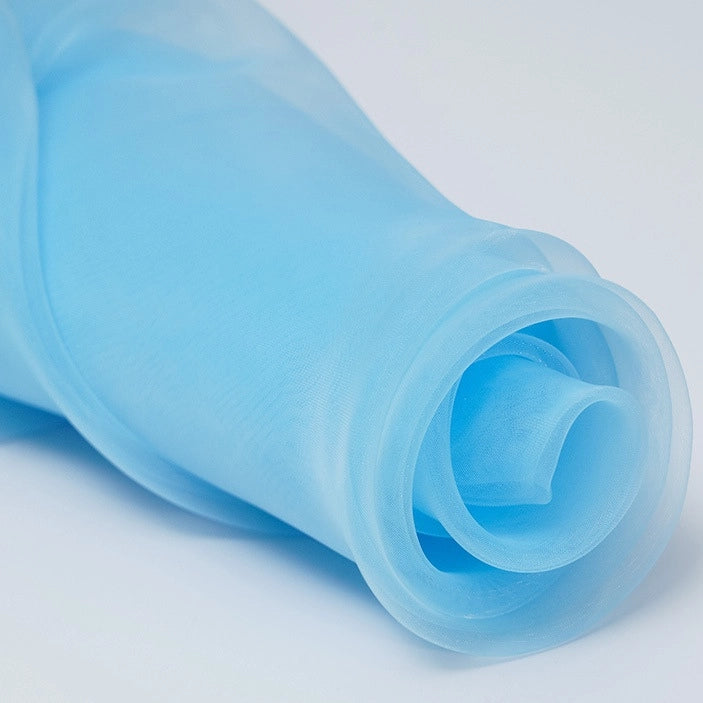 A close-up of Longan Craft's Silky Polyester Organza Fabric By The Yard, a premium solid color organza material in light blue, soft and sheer with a smooth texture, ideal for bridal gowns or evening dresses on a plain white background.