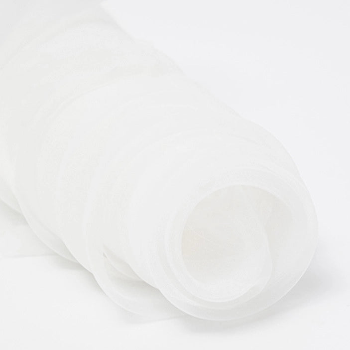 A close-up of Longan Craft's Silky Polyester Organza Fabric By The Yard in premium solid color, soft and sheer—ideal for bridal gowns or evening dresses—features the lightweight material rolled up on a white background.