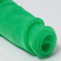 A close-up of Longan Craft's Silky Polyester Organza Fabric by the yard, in bright green premium solid color, partially unrolled to show its soft, sheer, and airy bridal quality against a plain white background.