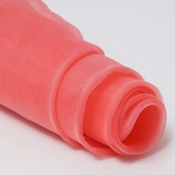 A close-up of Longan Craft’s Silky Polyester Organza Fabric by the Yard, a premium solid color, soft and sheer bridal organza material in light pink, displayed on a white surface—ideal for dresses or gowns.