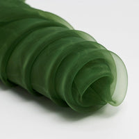 Longan Craft's Silky Polyester Organza Fabric By The Yard is a premium, soft, and sheer organza in dark green, shown loosely gathered on a white surface—ideal for evening dresses or elegant bridal gowns.