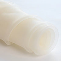 A close-up of Longan Craft’s Silky Polyester Organza Fabric By The Yard shows its soft, sheer white texture in a roll—premium solid organza ideal for evening dresses, bridal gowns, and special occasion decor.