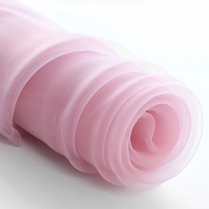 A close-up of Longan Craft’s Silky Polyester Organza Fabric By The Yard, a premium solid color organza in light pink. This soft, sheer bridal material is perfect for layered curves in gowns and evening dresses.