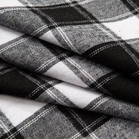 Close-up of folded Longan Craft Single Sided Sueded Plaid Flannel Fabric By The Yard, featuring a black, white, and gray plaid pattern. The medium weight polyester cotton flannel showcases premium soft texture with detailed woven intersecting lines and chevron-like designs within the darker stripes—ideal for clothing and craft projects.