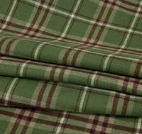 The Single Sided Sueded Plaid Flannel Fabric By The Yard from Longan Craft is a medium weight polyester cotton textile featuring a green and brown checkered pattern, with intersecting lines in shades of green, beige, and brown. This premium soft flannel clothing material is brushed for warmth and comfort, making it ideal for cozy projects. The neatly folded fabric showcases its appealing sueded texture and classic plaid design.