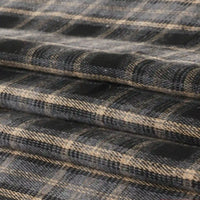 Neatly layered, folded fabric displays a black, beige, and gray plaid pattern with intersecting lines. This Single Sided Sueded Plaid Flannel Fabric By The Yard from Longan Craft features premium medium weight polyester cotton material and a brushed finish for exceptional softness and warmth—an ideal choice for any flannel project.