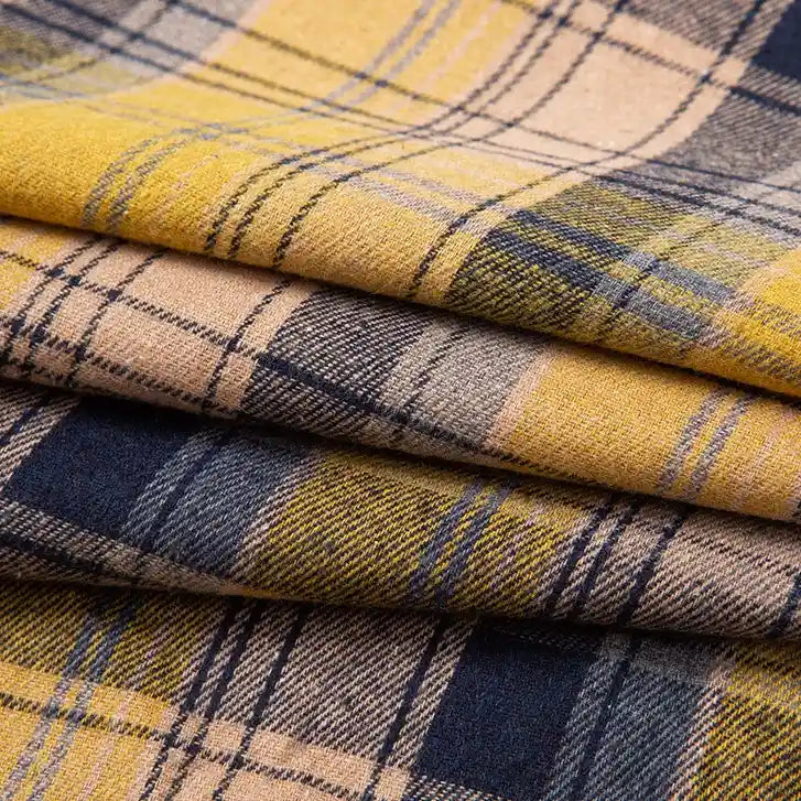 A close-up of folded Longan Craft Single Sided Sueded Plaid Flannel Fabric By The Yard showcases its premium soft, medium weight polyester cotton textile, featuring a plaid pattern in yellow, navy blue, and beige tones.