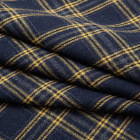 A close-up of folded Single Sided Sueded Plaid Flannel Fabric By The Yard from Longan Craft in a dark blue and yellow plaid pattern, highlighting the premium soft texture and cozy feel of this medium weight polyester cotton flannel textile—ideal for classic flannel clothing projects.