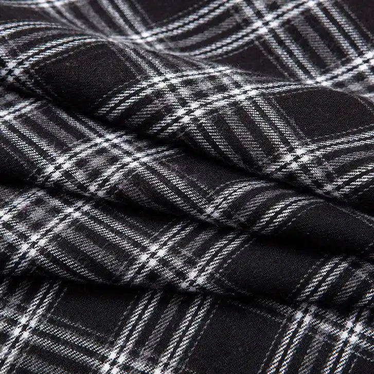 Close-up of Longan Craft’s Single Sided Sueded Plaid Flannel Fabric By The Yard, a medium weight polyester cotton textile in black with a white plaid pattern; the diagonal folds showcase the fabric’s soft sueded finish and emphasize the intersecting lines for added texture.