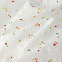 The Small Floral Printed Swiss Dot Fabric by Longan Craft features colorful tiny floral prints on soft, textured cotton with subtle dots and a slightly wrinkled charm. Ideal for cozy clothing! Available by the yard.