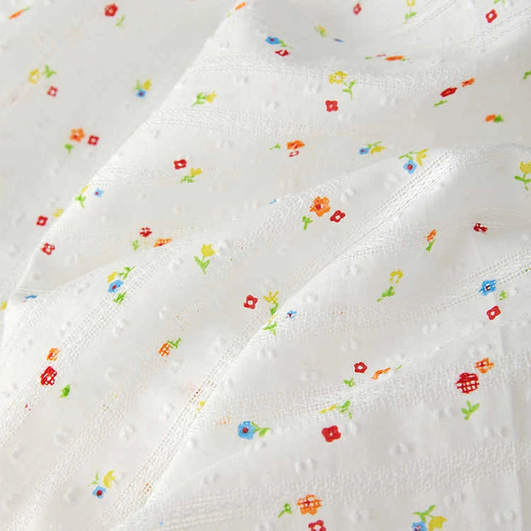 The Small Floral Printed Swiss Dot Fabric by Longan Craft features colorful tiny floral prints on soft, textured cotton with subtle dots and a slightly wrinkled charm. Ideal for cozy clothing! Available by the yard.