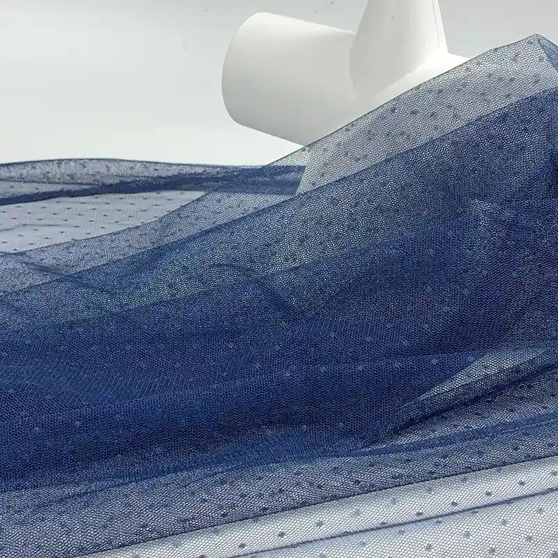 Longan Craft's Small Polka Dot Tulle Fabric By The Yard, a colorful polyester tulle, is unrolled to reveal its soft, sheer texture—ideal for dresses, veils, or elegant wedding accents.