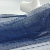 Longan Craft's Small Polka Dot Tulle Fabric By The Yard, a colorful polyester tulle, is unrolled to reveal its soft, sheer texture—ideal for dresses, veils, or elegant wedding accents.