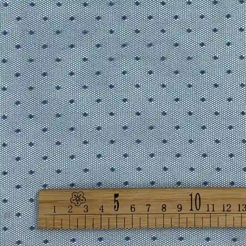 A close-up of Longan Craft’s Small Polka Dot Tulle Fabric By The Yard shows a light blue soft polyester tulle with a delicate dot pattern and a wooden ruler (4–13cm), ideal for dresses and veils.