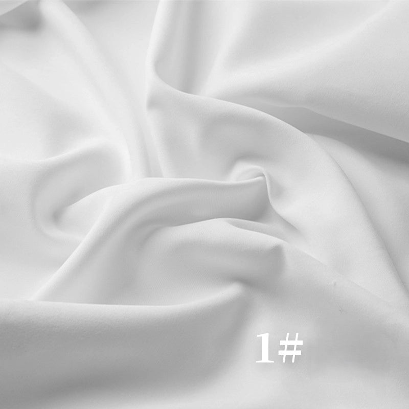 A close-up of Longan Craft's Solid Color Brushed Polyester Peachskin Fabric By The Yard shows gentle folds and creases in soft white midweight microsuede, with the text 1# in the bottom left corner.