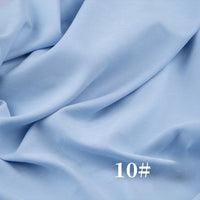 Longan Craft’s Solid Color Brushed Polyester Peachskin Fabric in light blue drapes softly with a flowing, velvety texture. White “10#” text appears in the lower right corner. Ideal for dressmaking and sold by the yard.