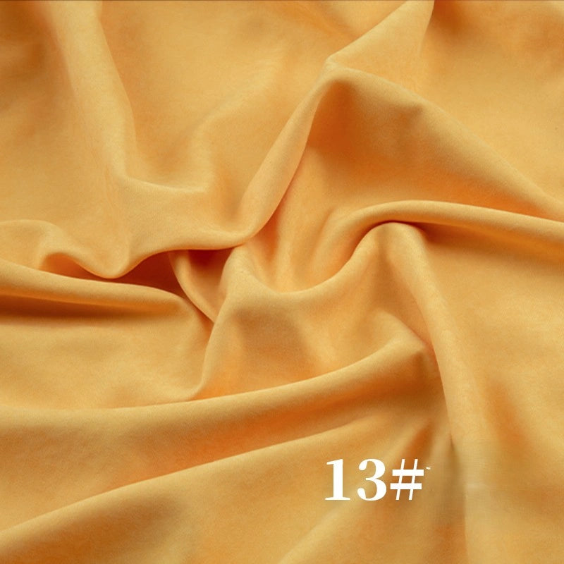 A close-up of Longan Craft's Solid Color Brushed Polyester Peachskin Fabric by the yard features gentle folds and wrinkles in soft, light orange. "13#" appears in white text at the bottom right. The midweight microsuede is ideal for dressmaking.