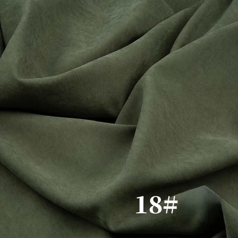 A close-up of olive green, velvety Solid Color Brushed Polyester Peachskin Fabric by Longan Craft shows visible folds. This midweight microsuede material is perfect for dressmaking. “18#” appears in white at the bottom right of the image.