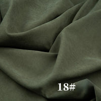 A close-up of olive green, velvety Solid Color Brushed Polyester Peachskin Fabric by Longan Craft shows visible folds. This midweight microsuede material is perfect for dressmaking. “18#” appears in white at the bottom right of the image.