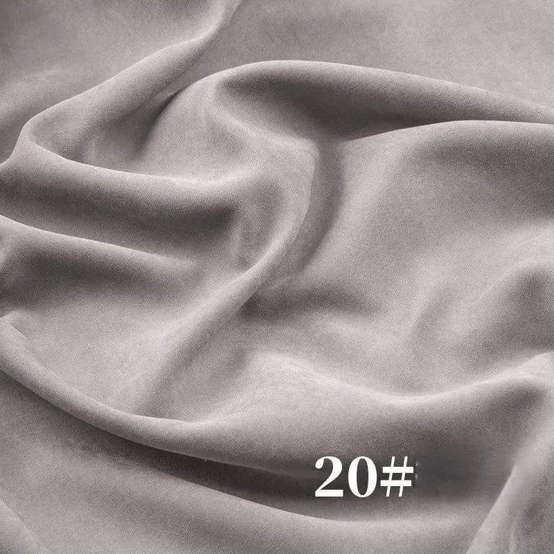 Light gray Solid Color Brushed Polyester Peachskin Fabric by Longan Craft, midweight microsuede with a velvety peachskin texture, shown with gentle folds and white "20#" at the bottom right corner—perfect for dressmaking.