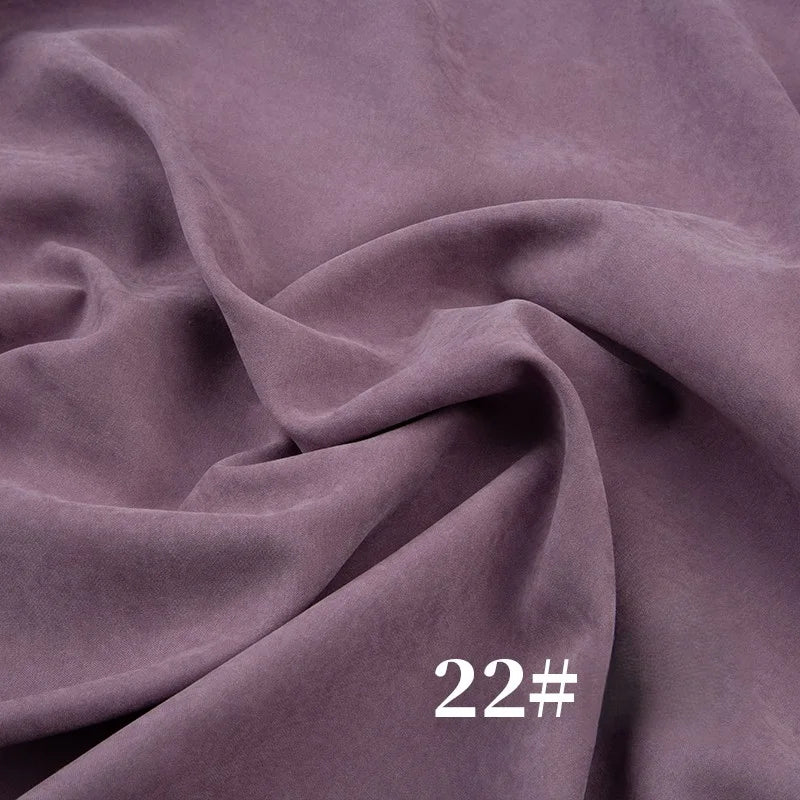 A close-up of Longan Craft’s Solid Color Brushed Polyester Peachskin Fabric By The Yard in soft mauve shows gentle folds and creases, with “22#” in white text—ideal midweight microsuede peachskin for dressmaking.