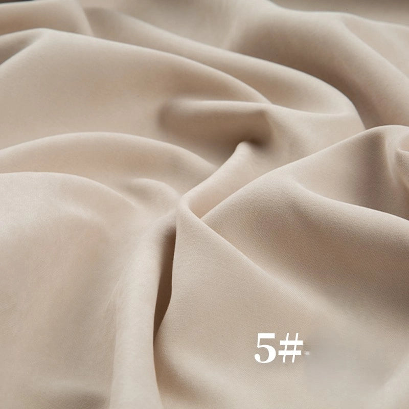 A close-up of Longan Craft’s Solid Color Brushed Polyester Peachskin Fabric By The Yard, midweight microsuede with a velvety texture, in light beige. "5#" appears in white text at the lower right. Ideal for dressmaking.