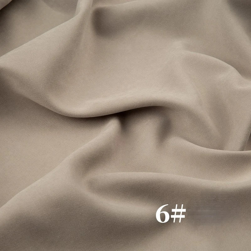 Longan Craft Solid Color Brushed Polyester Peachskin Fabric by the yard features a velvety, midweight microsuede texture ideal for dressmaking. Image shows beige fabric (#6) with a soft drape and white text in the lower right corner.