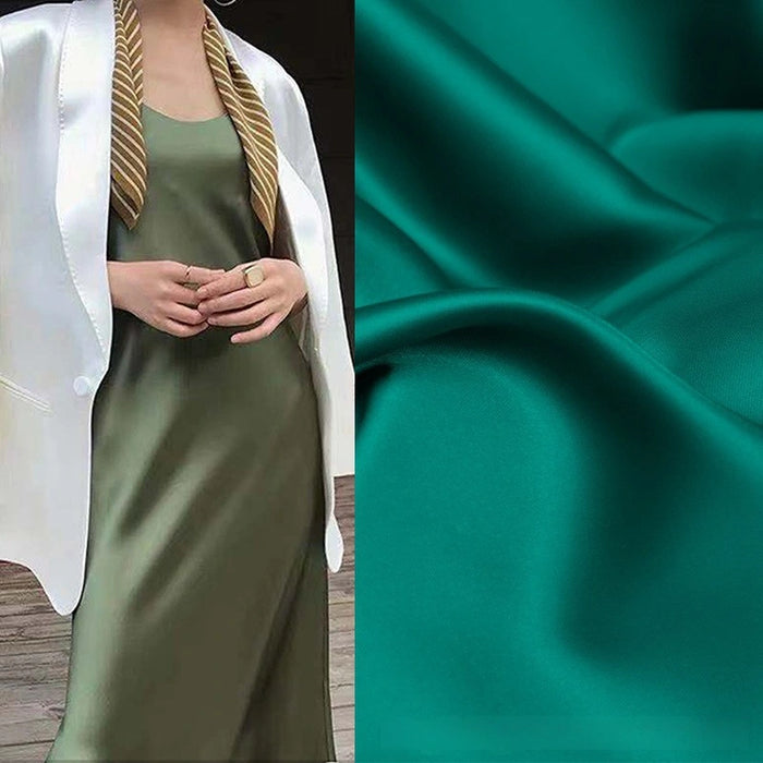 A woman wears a shiny olive slip dress and white blazer with a striped scarf. Beside her is a close-up of Longan Craft’s Solid Color Charmeuse Satin Fabric, highlighting its thick bridal satin texture and smooth, glossy finish.