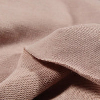 A close-up of Longan Craft's Solid Color Cotton French Terry Fabric By The Yard highlights its soft, thick texture and weave, ideal for hoodies. Slight folds show the difference between the outer and inner surfaces.