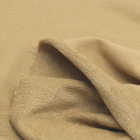 A close-up of Longan Craft Solid Color Cotton French Terry Fabric by the yard, partially folded to reveal both its soft textured underside and smooth top surface—ideal thick material for hoodies.