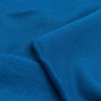 Close-up of Longan Craft Solid Color Cotton French Terry Fabric By The Yard shows two textures: one side smooth, the other more textured like sweatshirt fabric, separated by a seam. Ideal thick fabric for hoodies.