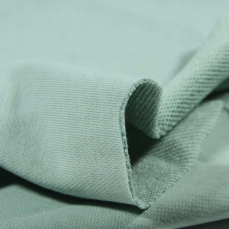 A close-up of Longan Craft’s Solid Color Cotton French Terry Fabric by the Yard, highlighting its smooth, slightly stretchy thick ribbed texture—ideal for hoodies and comfortable clothing.