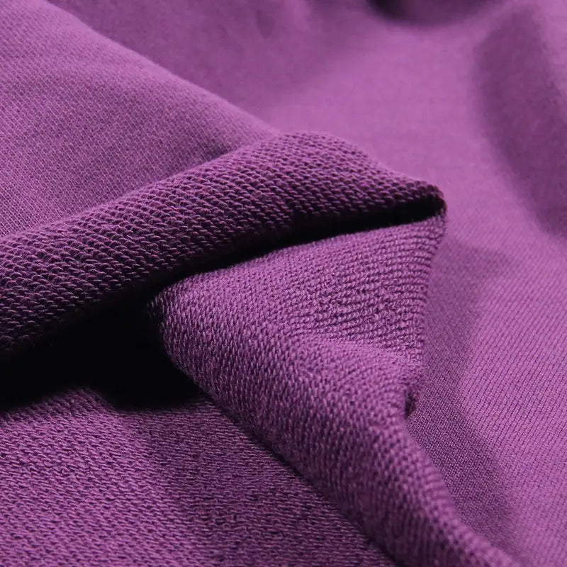 A close-up of Solid Color Cotton French Terry Fabric By The Yard from Longan Craft, showing the textured purple weave and soft, thick material—ideal for hoodies.