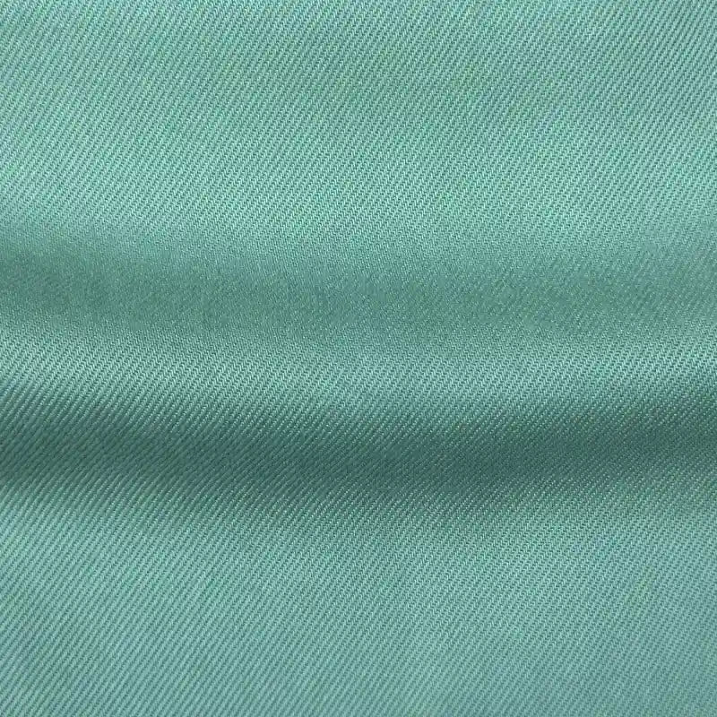 Close-up of Longan Craft’s Solid Color Denim Lyocell Fabric By The Yard, featuring a soft diagonal weave in light teal. This wrinkle-free, breathable material is perfect for comfy jeans and other projects.