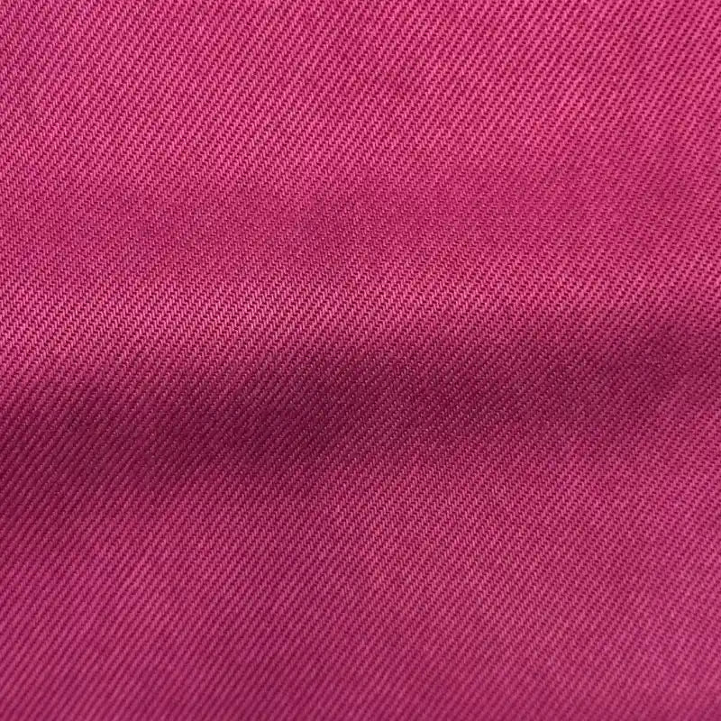 Close-up of Longan Craft Solid Color Denim Lyocell Fabric by the yard, featuring pink-dyed, wrinkle-free material with a diagonal weave pattern and fine texture—ideal for breathable, comfy jeans.